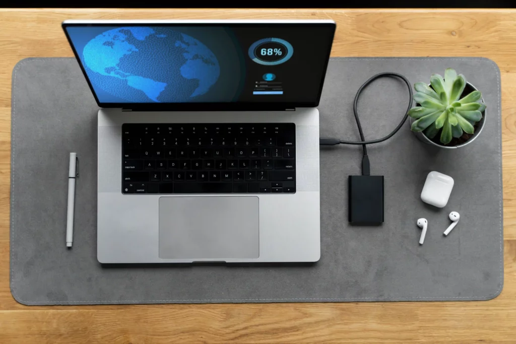 Modern workspace setup showing how to extend laptop lifespan with an external SSD, charging cable, and clean environment.